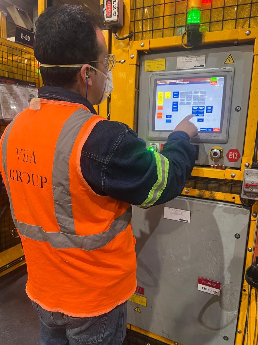 Técnico de VIIA GROUP operando HMI Allen-Bradley en planta industrial